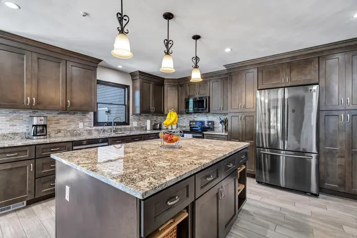 Completed dark-stained kitchen with granite countertops